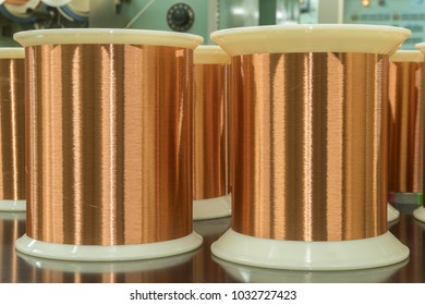 Standard Copper Wire Enamel In A Bobbin On The Table, Steel Floor In The Factory. The Backdrop Is A Machine. Winding Machine