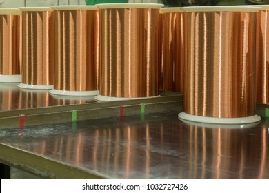 Standard Copper Wire Enamel In A Bobbin On The Table, Steel Floor In The Factory. The Backdrop Is A Machine. Winding Machine