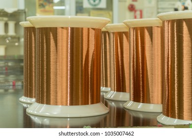 Standard Copper Wire Enamel In A Bobbin On The Table, Steel Floor In The Factory. The Backdrop Is A Machine. Winding Machine