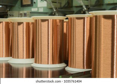 Standard Copper Wire Enamel In A Bobbin On The Table, Steel Floor In The Factory. The Backdrop Is A Machine. Winding Machine