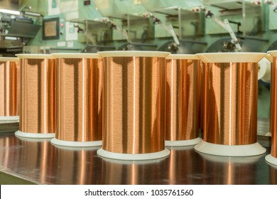 Standard Copper Wire Enamel In A Bobbin On The Table, Steel Floor In The Factory. The Backdrop Is A Machine. Winding Machine