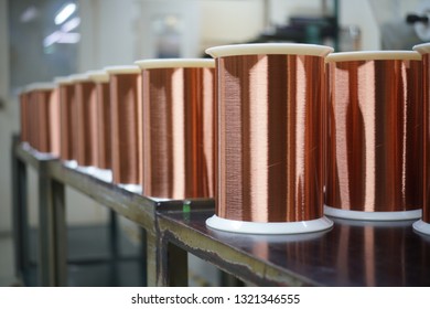 Standard Copper Wire Enamel In A Bobbin On The Table, Steel Floor In The Factory. The Backdrop Is A Machine. Winding Machine