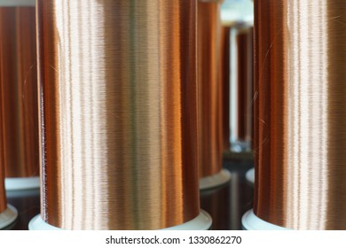 Standard Copper Wire Enamel In A Bobbin On The Table, Steel Floor In The Factory. The Backdrop Is A Machine. Winding Machine