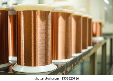 Standard Copper Wire Enamel In A Bobbin On The Table, Steel Floor In The Factory. The Backdrop Is A Machine. Winding Machine