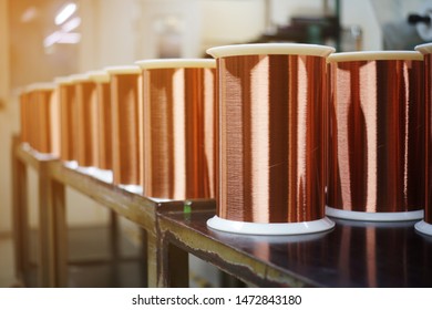 Standard Copper Wire Enamel In A Bobbin On The Table, Steel Floor In The Factory. The Backdrop Is A Machine. Winding Machine