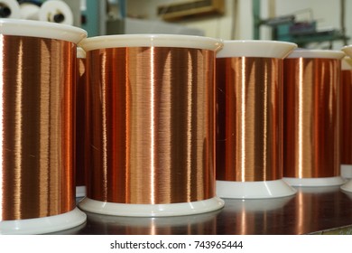 Standard Copper Wire Enamel In A Bobbin On The Table, Steel Floor In The Factory. The Backdrop Is A Machine. Winding Machine