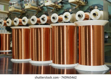 Standard Copper Wire Enamel In A Bobbin On The Table, Steel Floor In The Factory. The Backdrop Is A Machine. Winding Machine