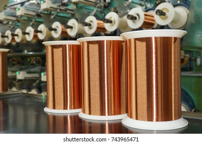 Standard Copper Wire Enamel In A Bobbin On The Table, Steel Floor In The Factory. The Backdrop Is A Machine. Winding Machine