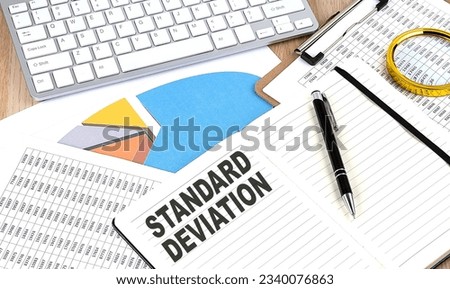 STANDARD DEVIATION text on a notebook with chart and keyboard