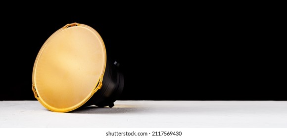 Standard reflector with a matte yellow diffuser on a black background. Attachment for studio flash with bowens mount.