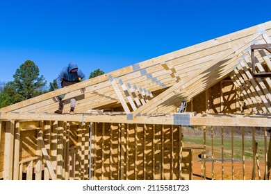 Standard timber framed building with close up on the roof trusses workers nailing wood beams