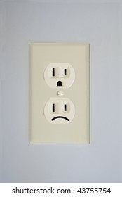 A Standard Wall Electrical Outlet Contains Two Surprised Faces. This One Has One Replaced By A Sad Face.