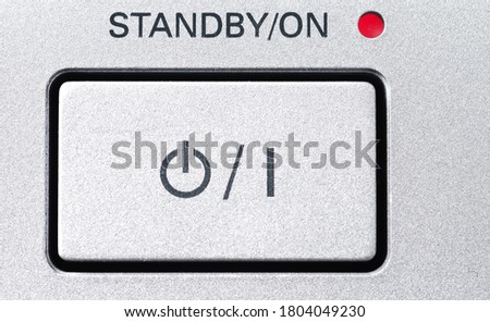 Standby-button in a gray with a grainy texture. With red LED.