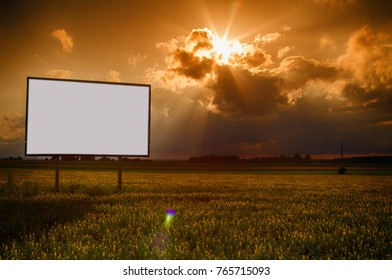 Standing Alone Billboard In A Field On A Background Of Clouds And A Passing Sun