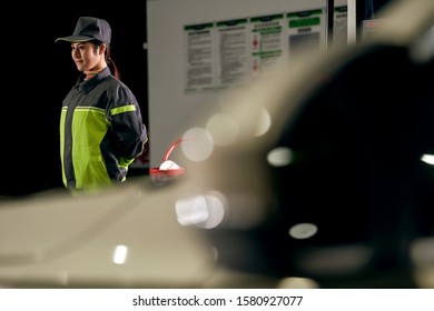 Standing Asian Female Gas Station Employee