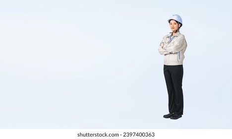 Standing Asian woman wearing work clothes. Engineer. Industrial worker. Wide angle visual for banners or advertisements. - Powered by Shutterstock