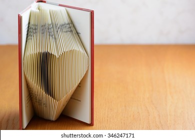 Standing book with folded pages to form a lovely heart. Book folding is an art form that is growing very popular in the crafting community. Copy space to right.
