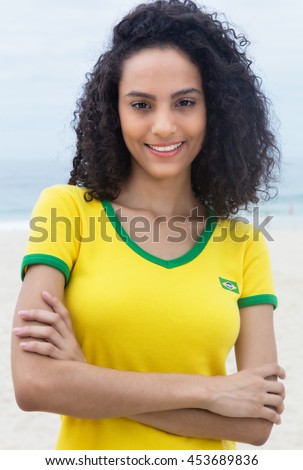 Standing brazilian sports fan with curly hair and crossed arms