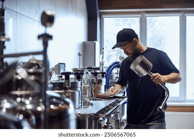 Standing in brewery, technologist taking notes during checking brewing process and equipment. Science and craft in beer production. Concept of beer, brewery, manufacture, quality control - Powered by Shutterstock