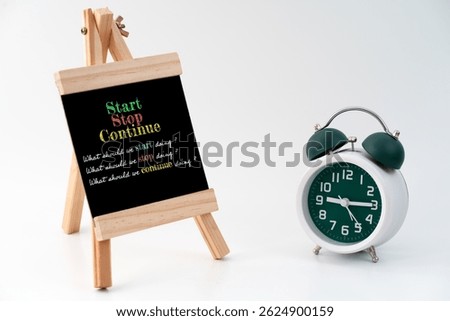 A standing chalkboard with markers displaying a Start-Stop-Continue framework. The scene illustrates a structured Start-Stop-Continue exercise, commonly used for evaluating team performance