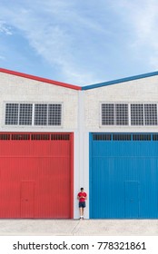 Standing man between red and blue doors in outdoors full lenght portrait