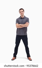 Standing Man Crossing His Arms And His Legs Apart Against White Background