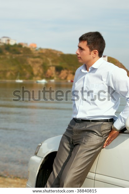 Standing man near the car\
at the seaside