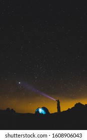 Standing man with torch light looking the black space night galaxy and enjoy th eoutdoor leisure activity in alternative cemping vacation travel