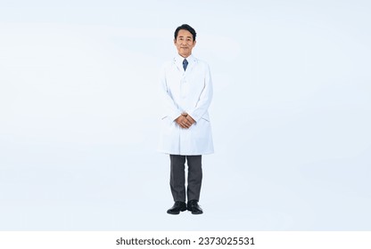 Standing middle aged Asian doctor.