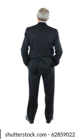 Standing middle aged businessman with both hands in his pockets. Business man is in full  length shot of the mans back over a white background.
