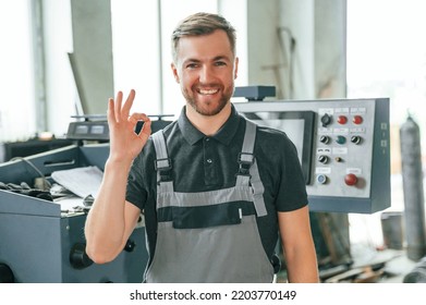 Standing near operate device. Man in uniform is in workstation developing details of agriculture technique. - Shutterstock ID 2203770149