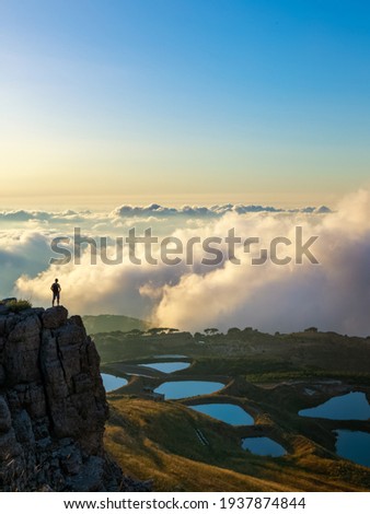 Standing on a cliff above the clouds and a view of blue natural lakes