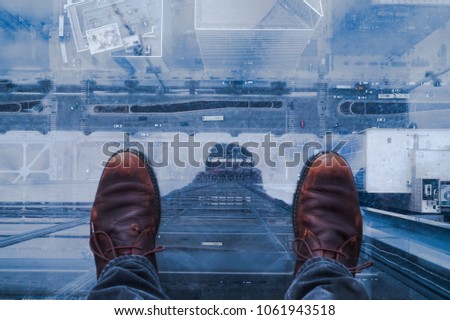 Standing on glass floor on edge of skyscraper in Chicago and looking down