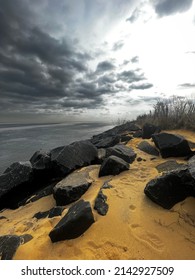 Standing On A Protective Rock Barrier, Or Sea Wall, Overlooking Raritan Bay As A Storm Approaches With Ominous Looking Clouds.