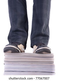 Standing on the stack of magazines.