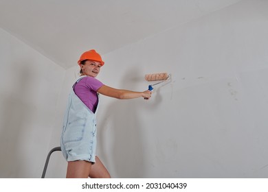 Standing On A Stepladder Painting The Wall