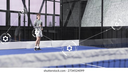 Standing player holding racket, preparing on blue court with digital overlay, wearing sportswear. Athlete, glass, net, facility, lineart, visualization, hitech