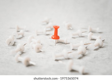 standing red thumbtack among blurred white thumbtacks on grunge grey background , for outstanding leader, winner , strongest ,success , the best things or idea, winner among loosen concept