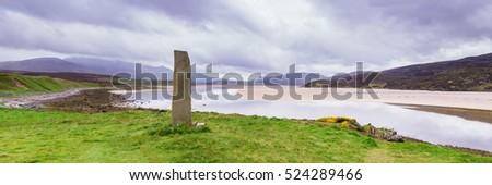 Standing stone with ancient Keltic symbols by the Kyle of Durness at Keoldale, near Durness, Sutherland, Scotland, UK