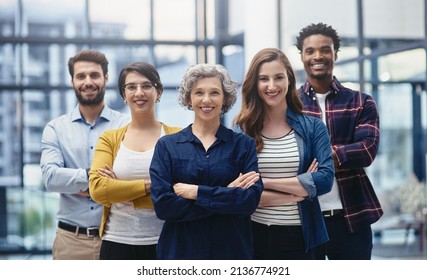 Standing Tall As A Strong Team. Portrait Of A Group Of Creatives Standing With Their Arms Folded In An Office.