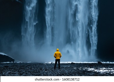 Standing Under Waterfall With Yellow Jacket.