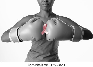 Standing woman for breast cancer awareness with ribbon and boxing gloves on white background - Powered by Shutterstock