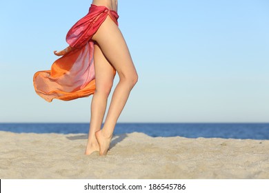 Standing woman legs posing on the beach wearing a pareo with the horizon in the background                 - Powered by Shutterstock