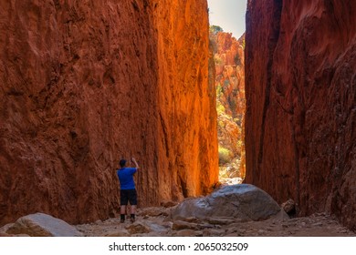 STANDLEY CHASM, AUSTRALIA - Aug 25, 2017: An adventurous male taking a picture of the Standley Chasm rocky cliffs in Australia