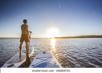 Standup paddler at the lake during sunset