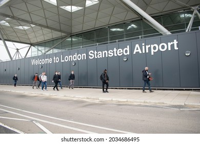 Stansted, Essex, England- August 17, 2021. Welcome Sign Of Stansted Airport With People Walking By.