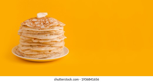 Staple of yeast fluffy pancakes with butter. Spring holiday Traditional Russian Shrovetide Maslenitsa week or pancake tuesday. american crepes isolated on yellow background. banner, place for text - Shutterstock ID 1936841656