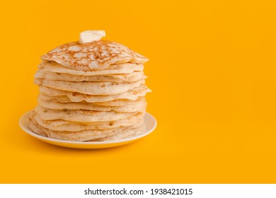 Staple of yeast fluffy pancakes with butter. Spring holiday Traditional Russian Shrovetide Maslenitsa week or pancake tuesday holiday. american crepes isolated on yellow background - Shutterstock ID 1938421015