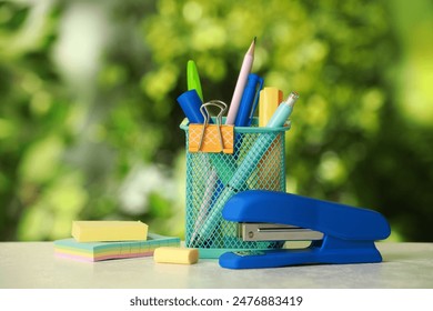 Stapler, holder and other different stationery on white table - Powered by Shutterstock