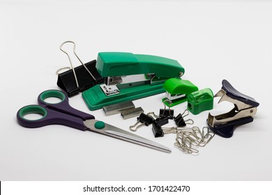 Staplers with staples, binder clips, scissors, pencil sharpener, staple remover isolated on white background. Top view, closeup, office design idea